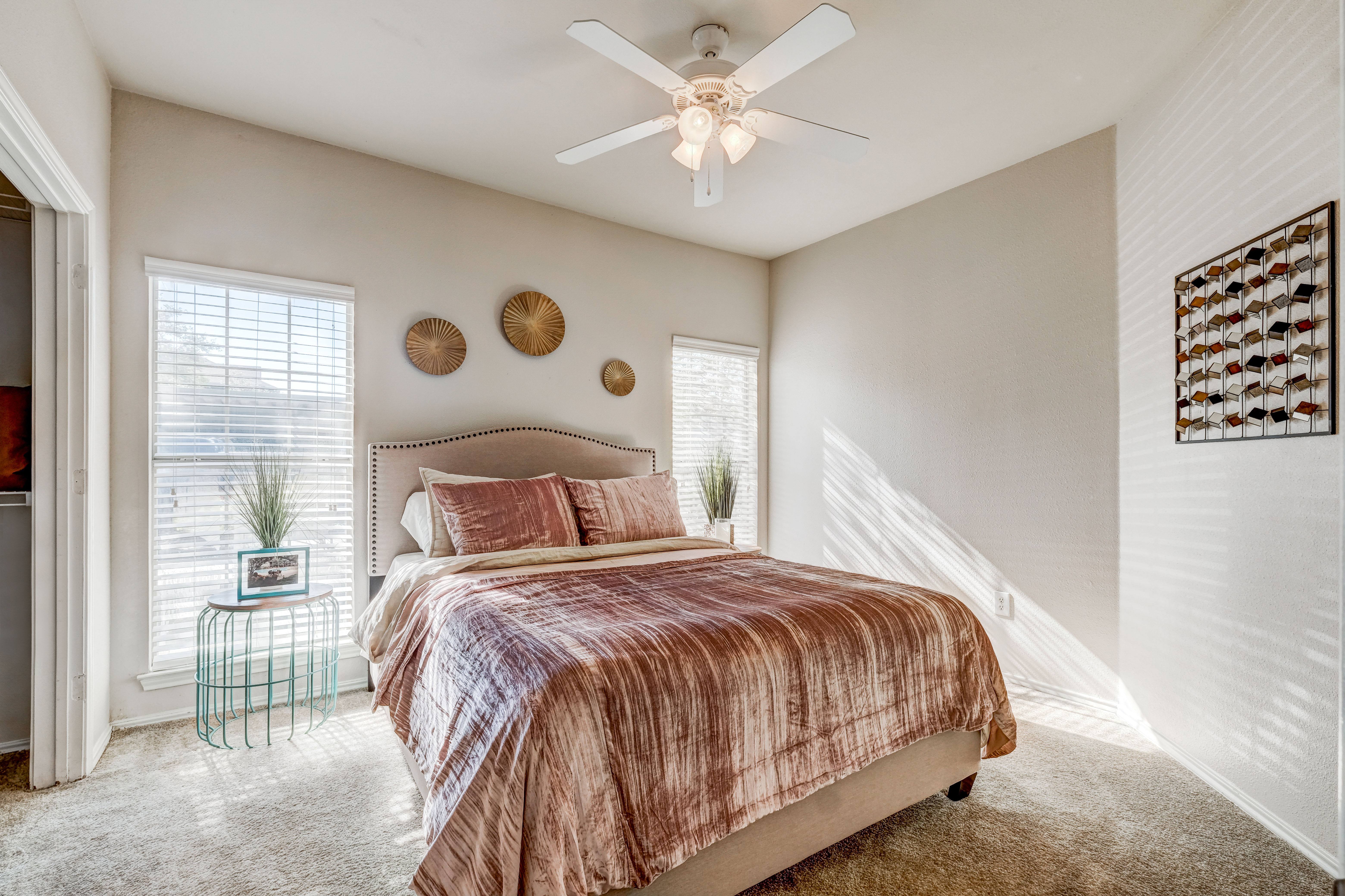Bedroom with ceiling fan and ample natural lighting